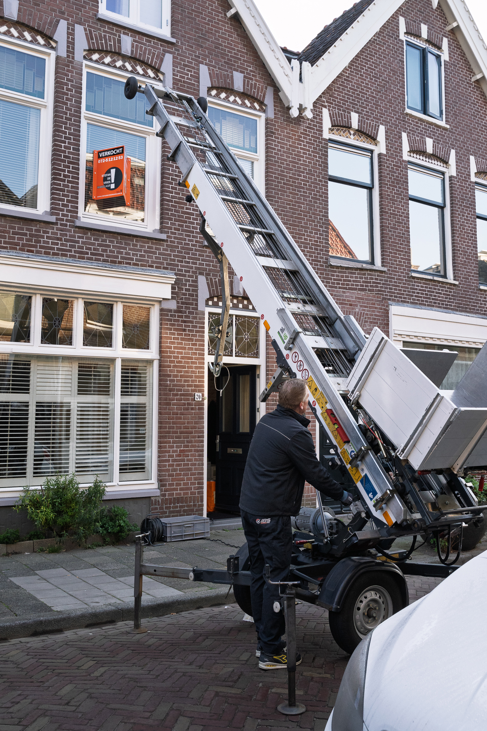 Medewerker van IBS bedient een verhuislift bij een woning